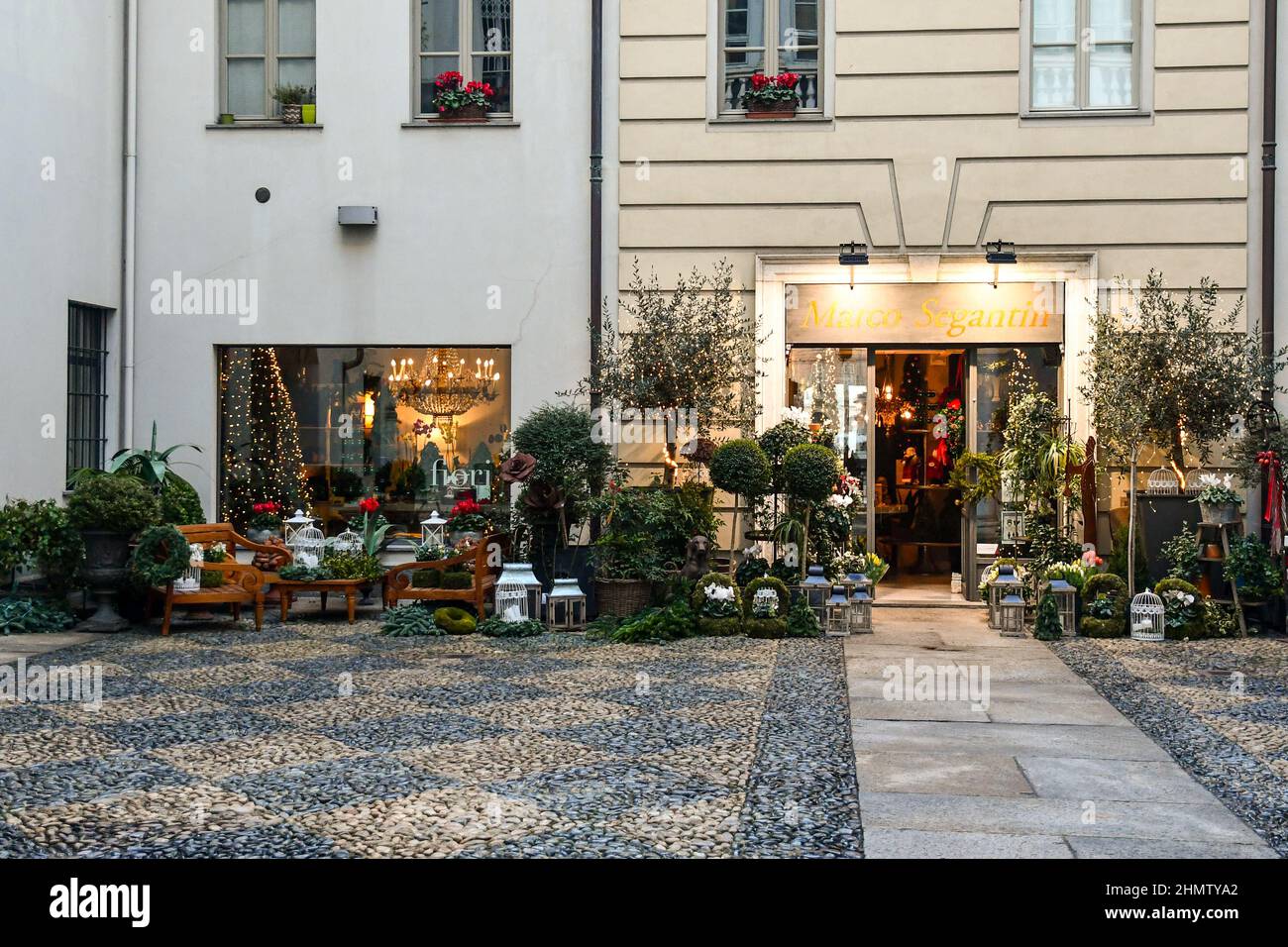 Ein Blumenladen mit vielen Topfpflanzen, die auf der Vorderseite im Innenhof eines alten Palastes im historischen Zentrum von Turin, Piemont, Italien, ausgestellt sind Stockfoto