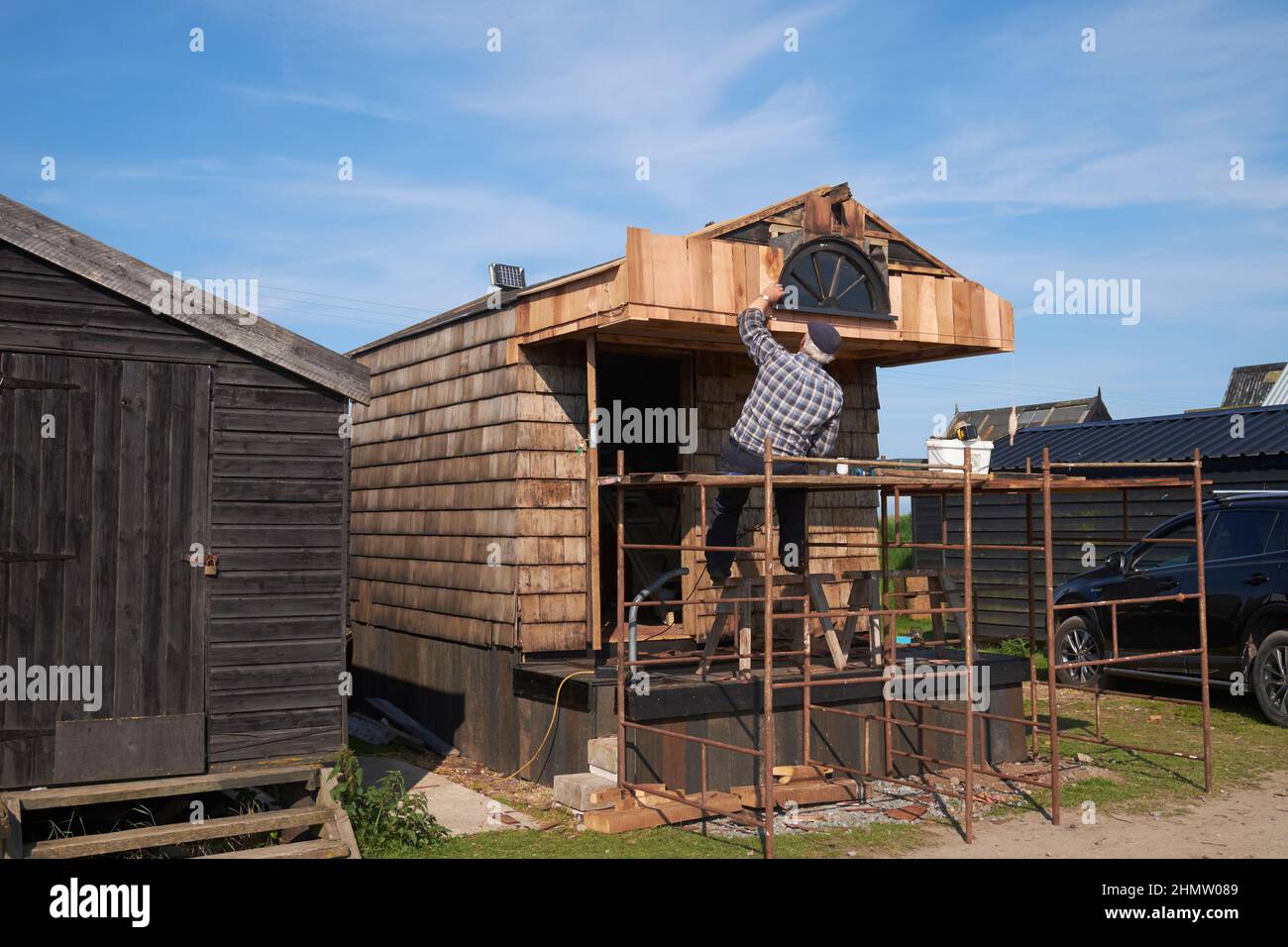 Mann bei der Renovierung einer Fischerhütte, Southwold Harbour, Suffolk, England. Stockfoto