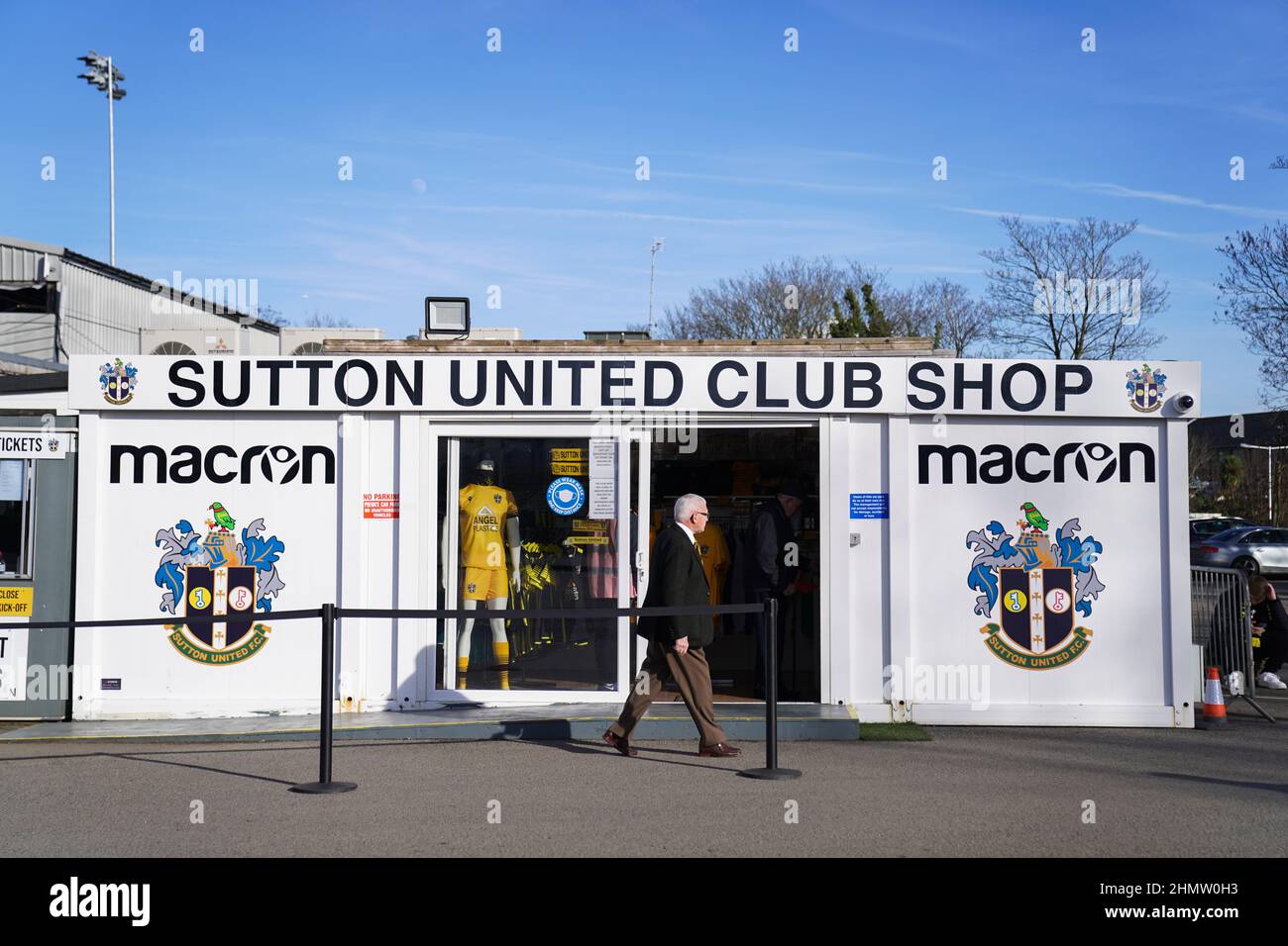 Ein Mann geht am Sutton United Club Shop vorbei, bevor es zum zweiten Spiel der Sky Bet League im VBS Community Stadium, London, geht. Bilddatum: Samstag, 12. Februar 2022. Stockfoto