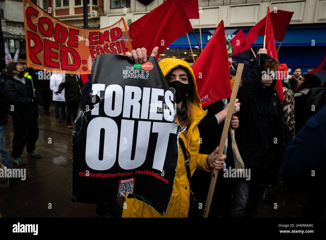 Manchester, Großbritannien. 12th. Februar 2022. Demonstranten marschieren mit Plakaten durch die Stadt. Hunderte von Menschen gehen auf die Straße, um gegen die steigenden Lebenshaltungskosten zu protestieren. Unter dem Motto „We Can't Pay for This Crisis“, organisiert von der Volksversammlung, werden landesweit Demonstrationen gegen die Torys und ihre Handhabung der aktuellen und sich immer weiter verschlechternden Situation, in der sich Tausende befinden, abgehalten. Kredit: Andy Barton/Alamy Live Nachrichten Stockfoto