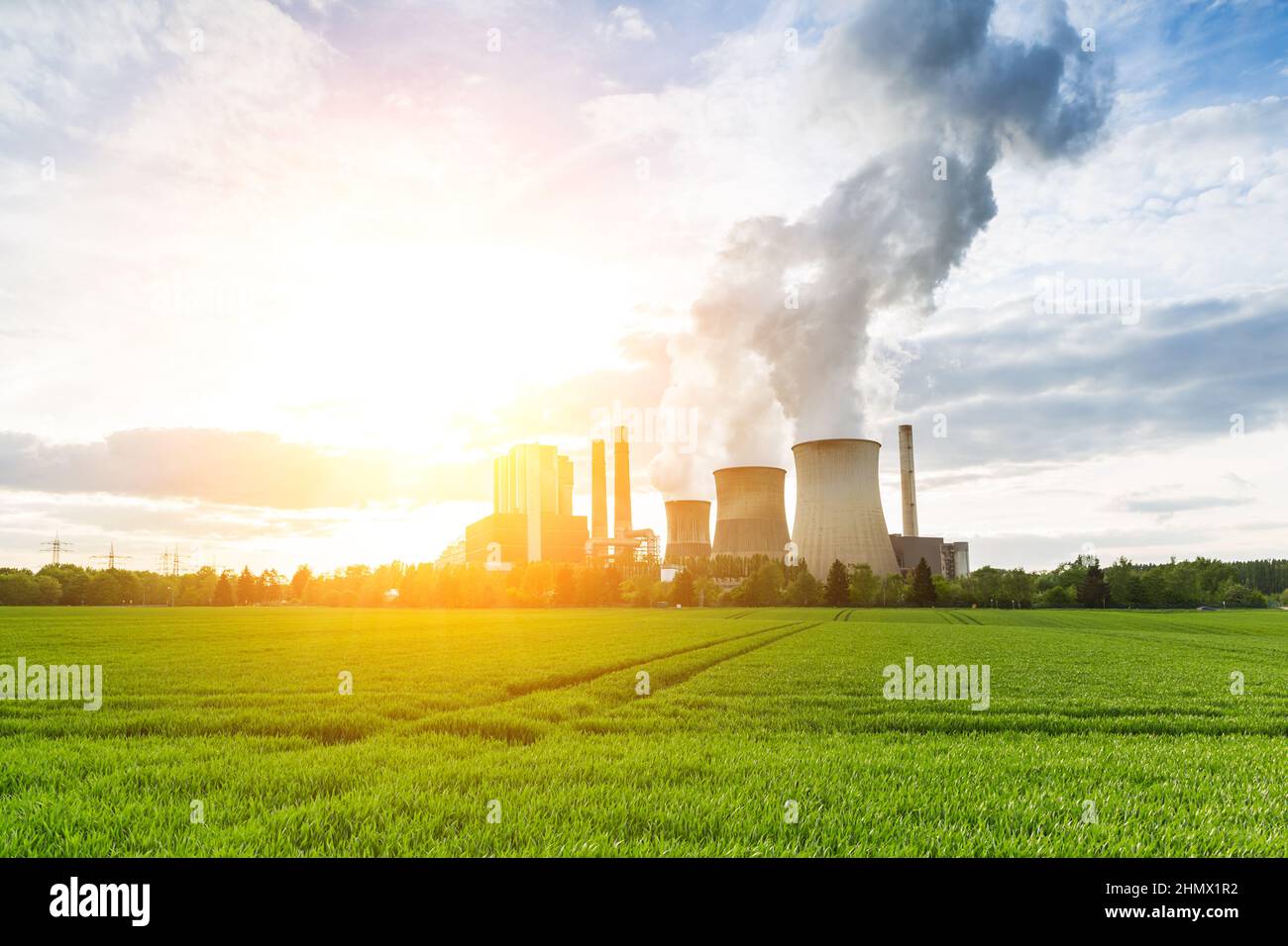 Braunkohlekraftwerk mit hellem Sonnenlicht und bewölktem Himmel Stockfoto