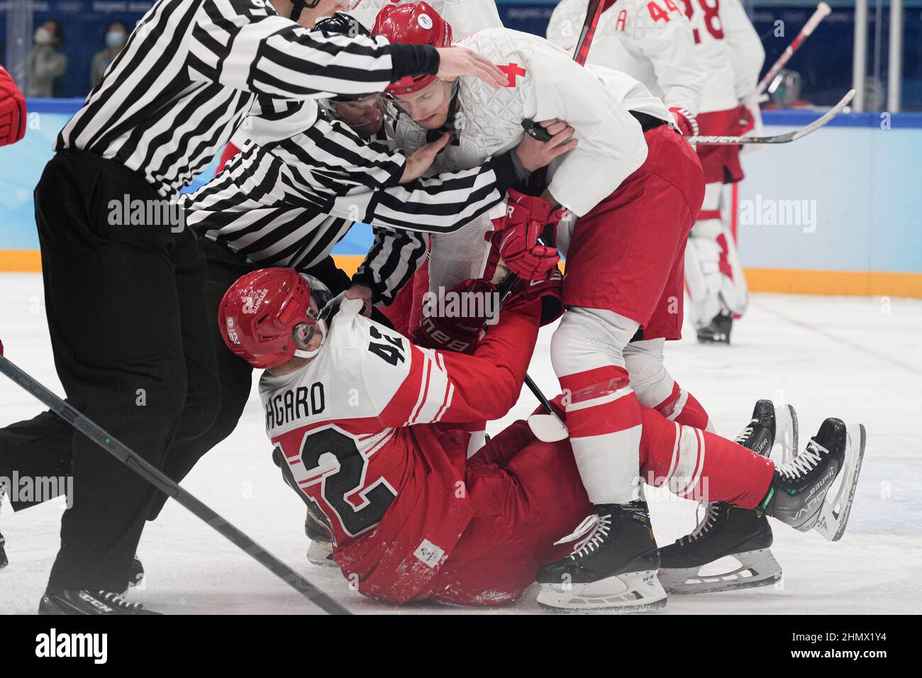 (220212) -- PEKING, 12. Februar 2022 (Xinhua) -- Alexander Yelesin (oben) vom ROC und Mikkel Aagaard (unten) von Dänemark treffen sich während der Vorrunde der Männer im Eishockey-Spiel der Gruppe B zwischen Dänemark und dem ROC im National Indoor Stadium in Peking, China, 11. Februar 2022. Als die chinesischen Eishockeyspieler bei den Olympischen Winterspielen 2022 in Peking auftauchten, zieht dieses Spiel immer mehr die Aufmerksamkeit der Öffentlichkeit auf sich. Im Wukesong Sports Center in Peking stellten Mitarbeiter der Eishockey-Veranstaltungen die Eiswürfel in Kühlboxen. Der Puck, aus vulkanisiertem Gummi, ist eine flache harte Scheibe, die ne Stockfoto