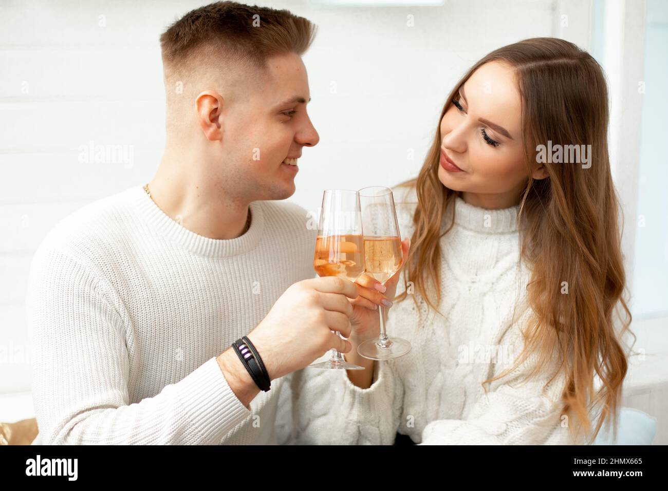 Junge schöne Menschen trinken Wein aus Gläsern, um Bekanntschaft zu feiern. Liebe auf den ersten Blick. Romantische Beziehungen. Liebe und Zärtlichkeit Stockfoto