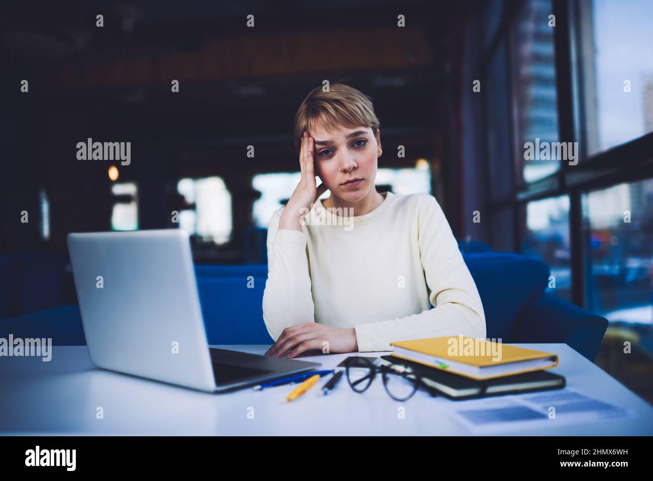 Müde Frau mit Laptop während der Arbeit fristgerecht Stockfoto