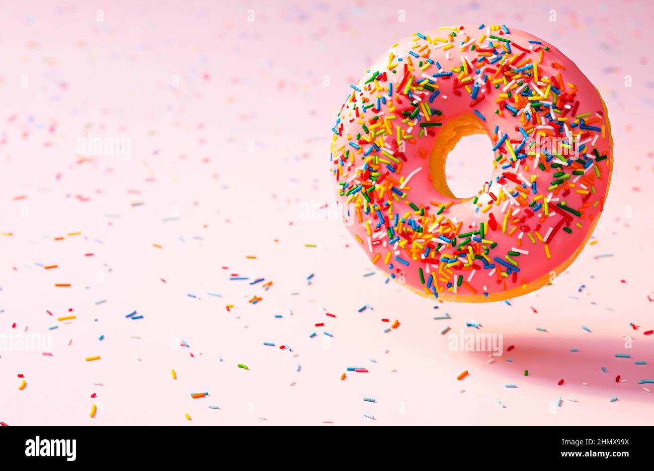 Farbenfrohe rosa Donut auf rosa Hintergrund gestreut Stockfoto