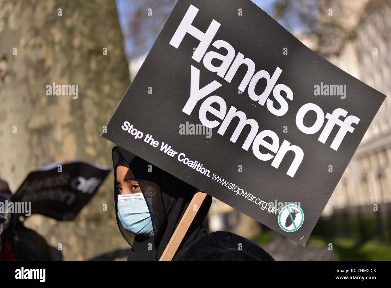 London, Großbritannien. 12th. Februar 2022. Ein Protestler hält während der Demonstration ein Plakat mit der Aufschrift "Hände weg vom Jemen" gegenüber der Downing Street.Protest gegen den anhaltenden Krieg im Jemen. Die Demonstranten forderten ein Ende der Waffenverkäufe an die saudische Koalition. Kredit: SOPA Images Limited/Alamy Live Nachrichten Stockfoto