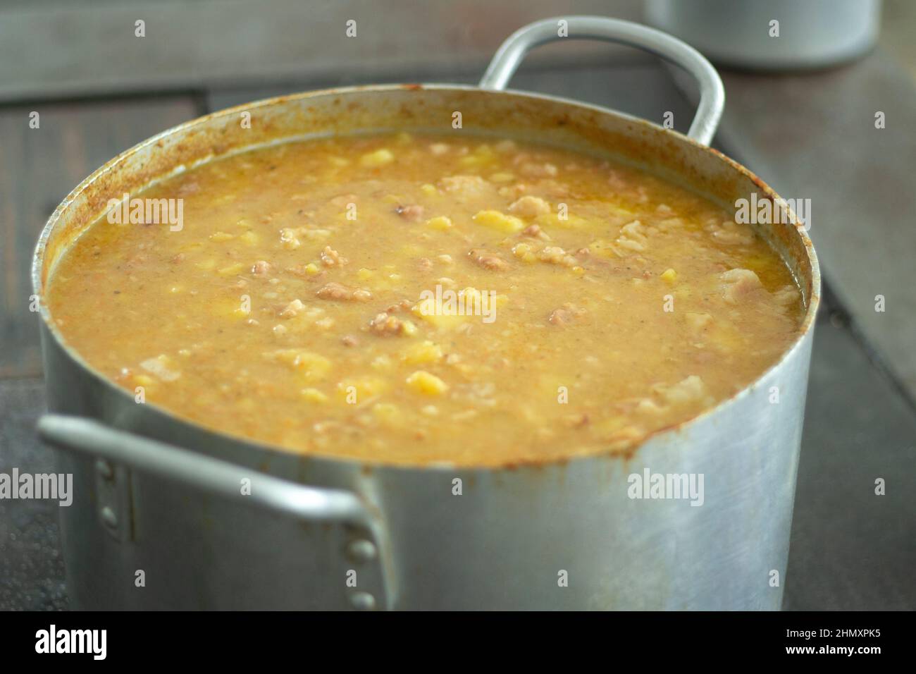 Suppe in Kochtopf. Großer Behälter mit Erbsensuppe in der Küche. Kochgeschirr aus Edelstahl. Stahltank mit Lebensmitteln im Esszimmer. Wir kochten das Abendessen. Stockfoto
