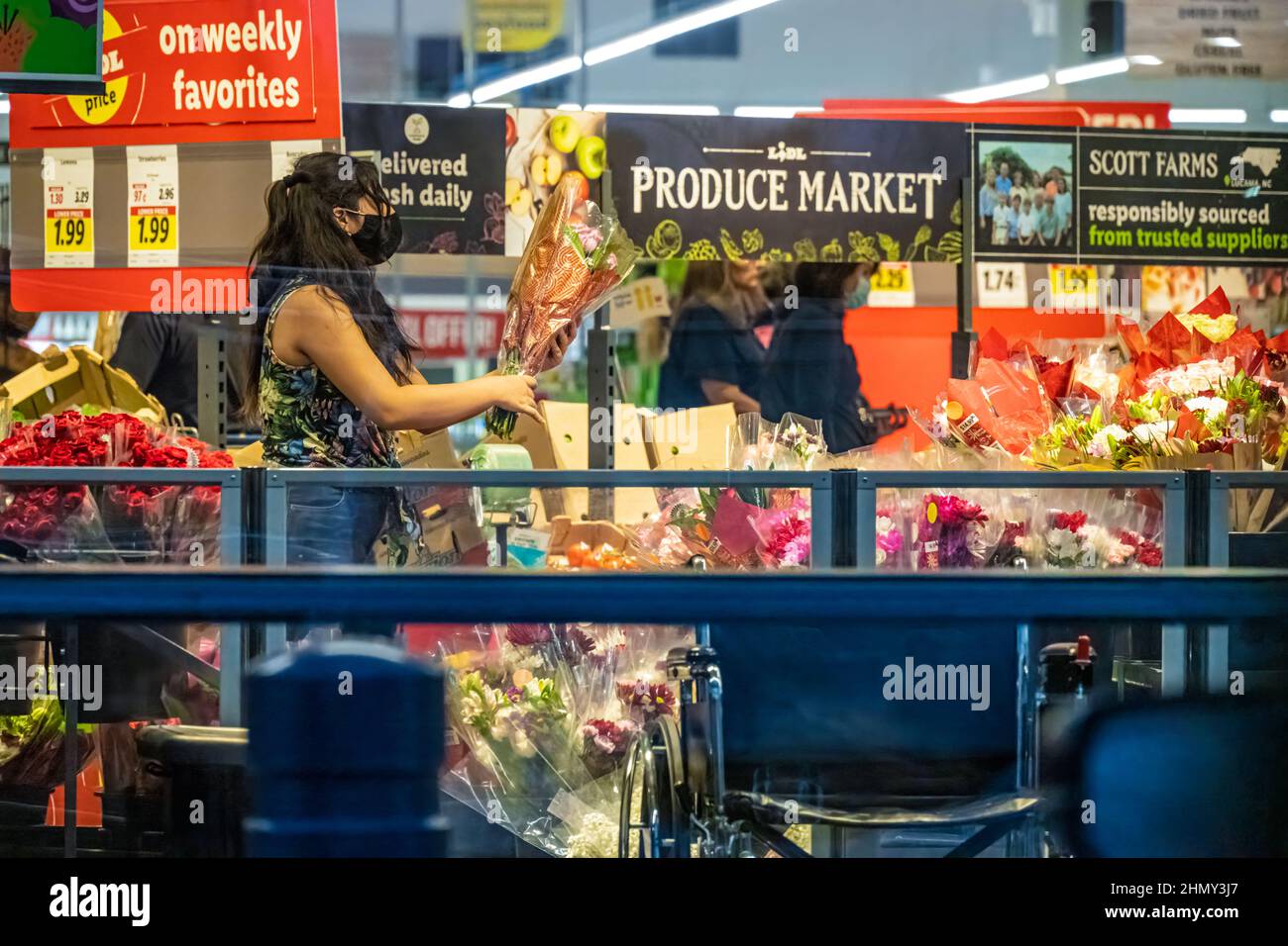Weibliche Shopper, die frische Blumen auf dem Lidl Food Market in Snellville (Metro Atlanta), Georgia, auswählt. (USA) Stockfoto