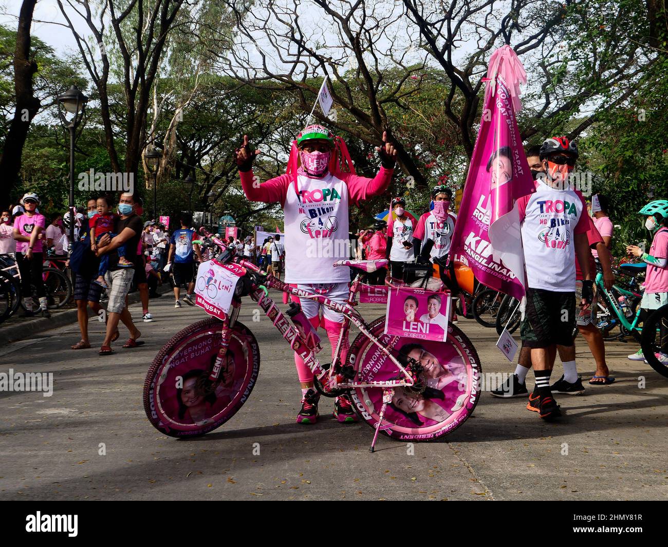 Quezon City, Philippinen. 13. Februar 2022, Quezon City, National Capital Region, Philippinen: Ein Radfahrer unterstützt Vizepräsident Leni Robredo mit Kampagnenplakaten auf seinem Fahrrad.die Vizepräsidentin der Philippinen, Maria Leonor, ''Leni'' G. Robredo, macht jetzt Kampagnen in Quezon City. Sie wirbt im Quezon City Memorial Circle für ihre großartigen Unterstützer, wo jeder Pink trägt. Rosa ist ihre Kampagnenfarbe. (Bild: © George Buid/ZUMA Press Wire) Bild: ZUMA Press, Inc./Alamy Live News Stockfoto