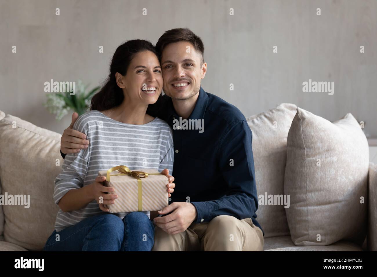 Aufgeregt Frau nimmt Geschenk von glücklichen Ehemann Stockfoto
