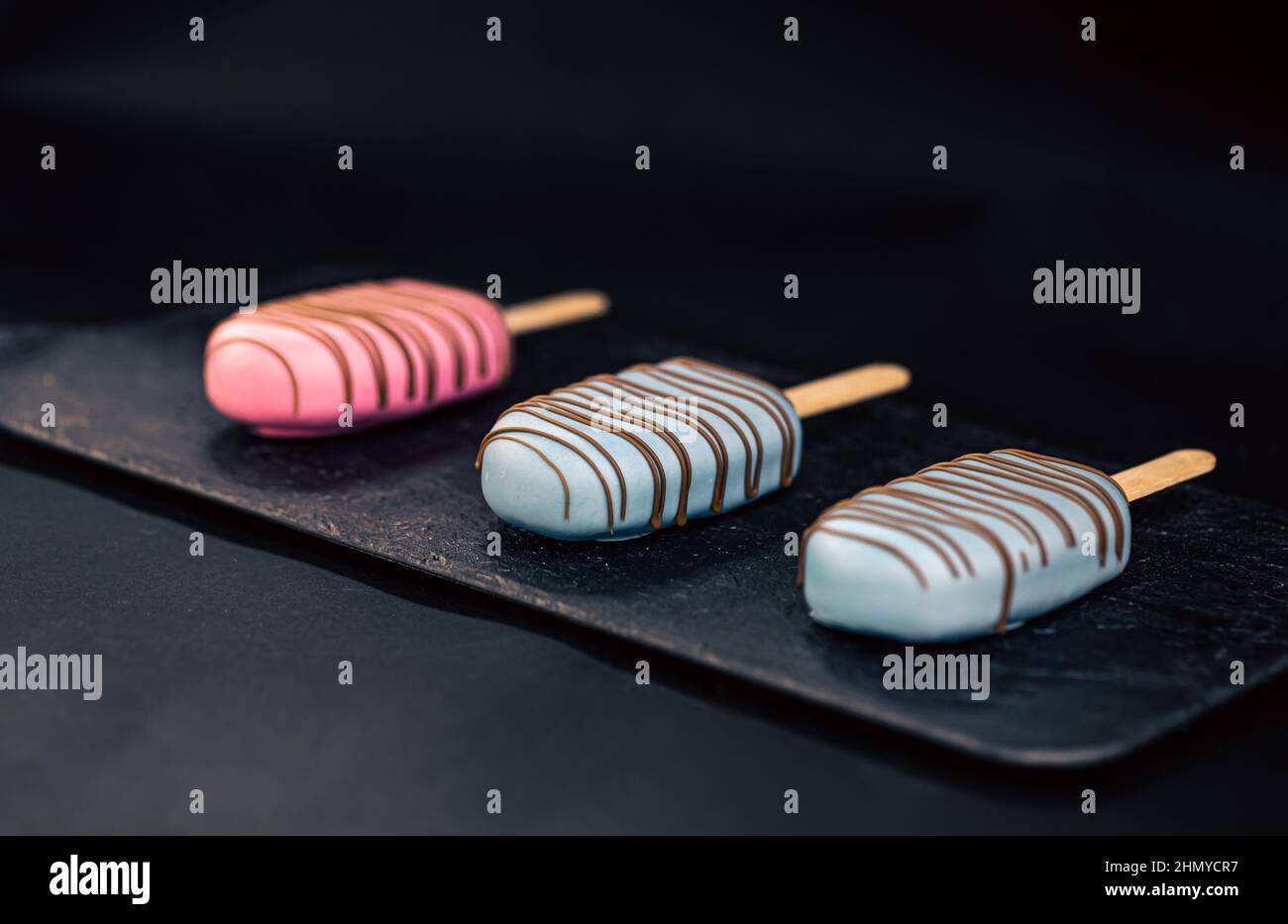 Dessert in Form von Eis aus dem Eis mit rosa und blauer Schokolade. Stockfoto