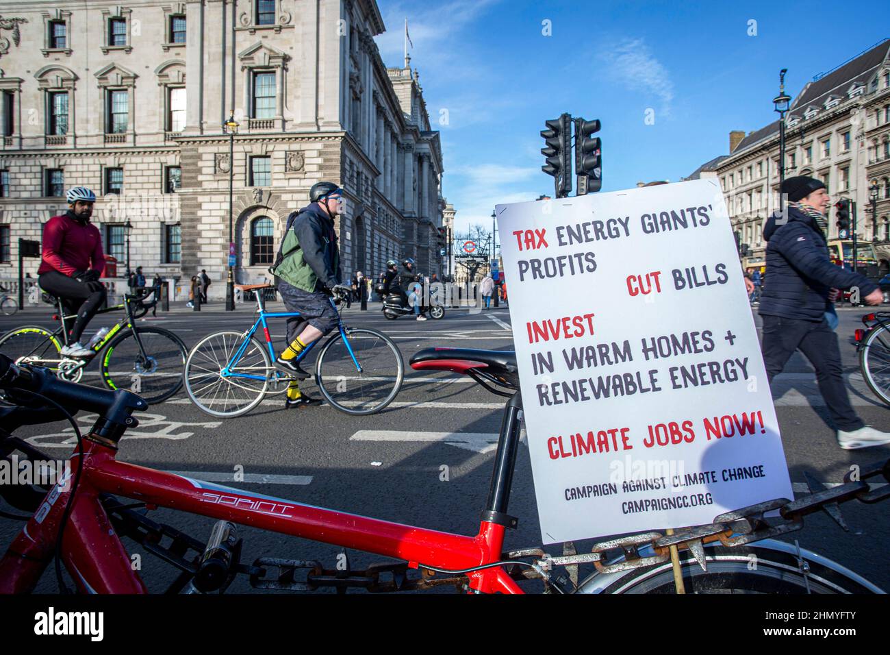 Radfahrer passieren Protest Zeichen gegen die steigenden Kraftstoffpreise und Lebenshaltungskosten.climat; Klima ändern Stockfoto
