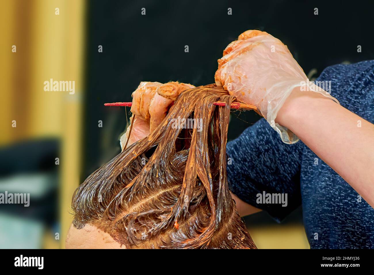 Der Prozess des Malens von Frauenhaaren in einem Friseurladen aus nächster Nähe Stockfoto