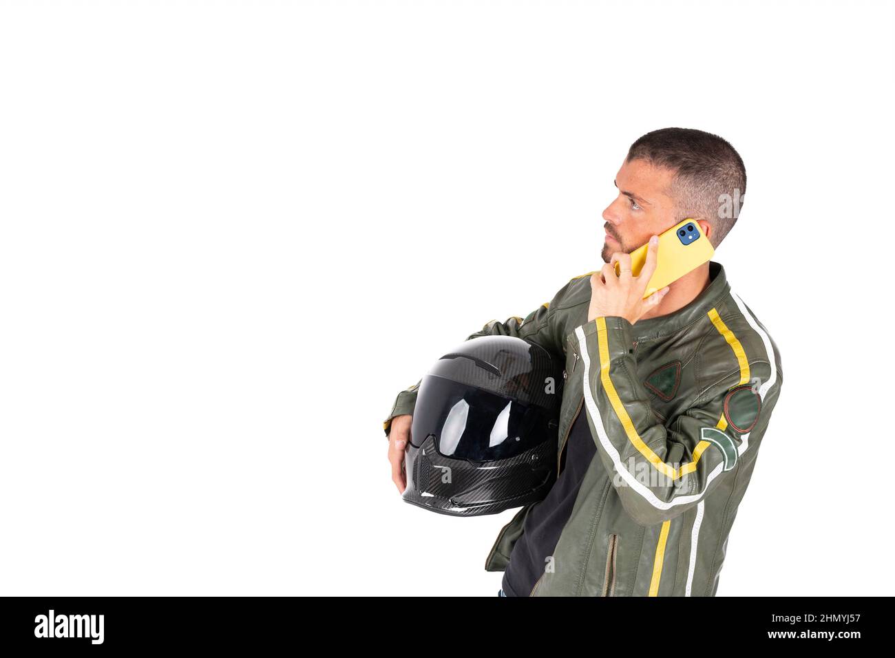 Motorradfahrer ruft am Telefon mit dem Helm auf seinem Arm auf weißem Hintergrund Stockfoto