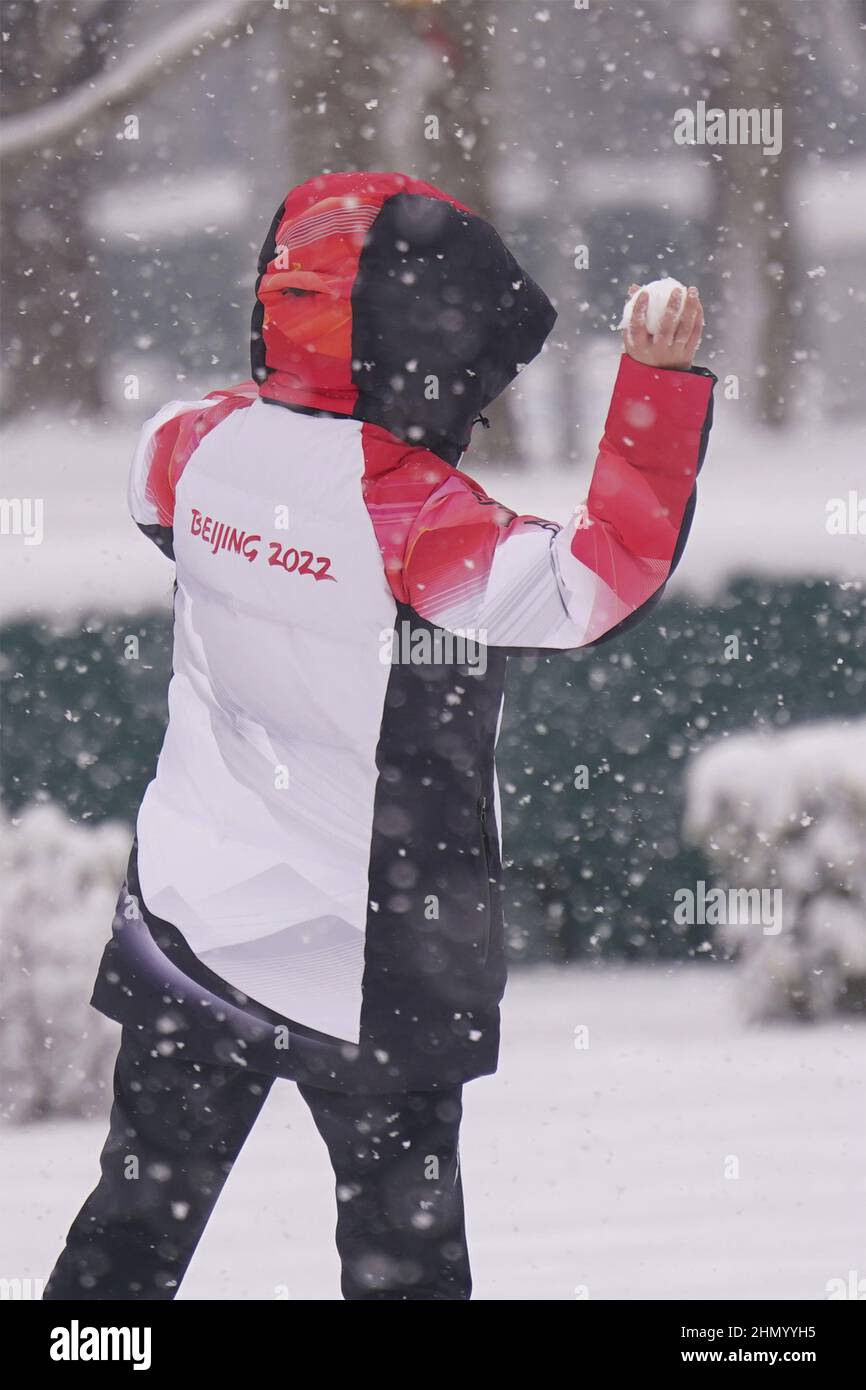 Ein Olympischer Freiwilliger wirft bei den Olympischen Winterspielen 2022 in Peking am Sonntag, den 13. Februar 2022, einen Schneeball während eines starken Schneefalls. Foto von Richard Ellis/UPI Stockfoto