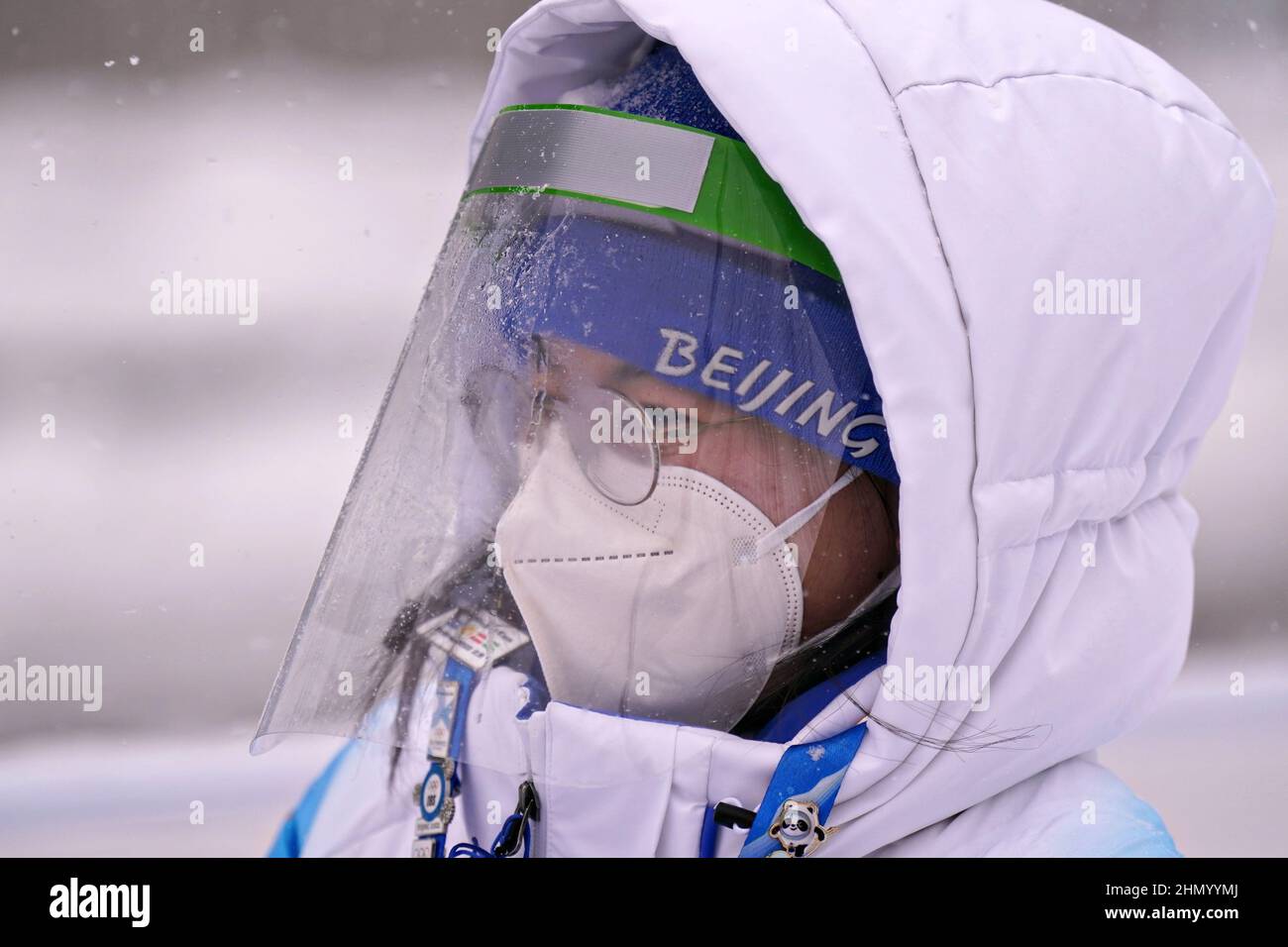 Bei den Olympischen Winterspielen in Peking 2022 am Sonntag, den 13. Februar 2022, trägt ein Olympischer Freiwilliger Schutz vor Covid bei starkem Schneefall. Foto von Richard Ellis/UPI Stockfoto
