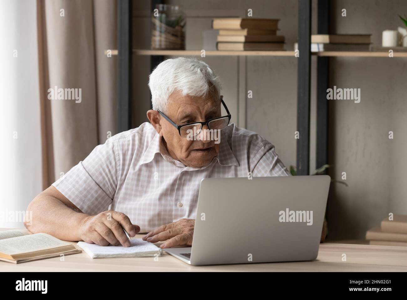 Fokussierter älterer 80s Student Mann, der Wissen erhält Stockfoto