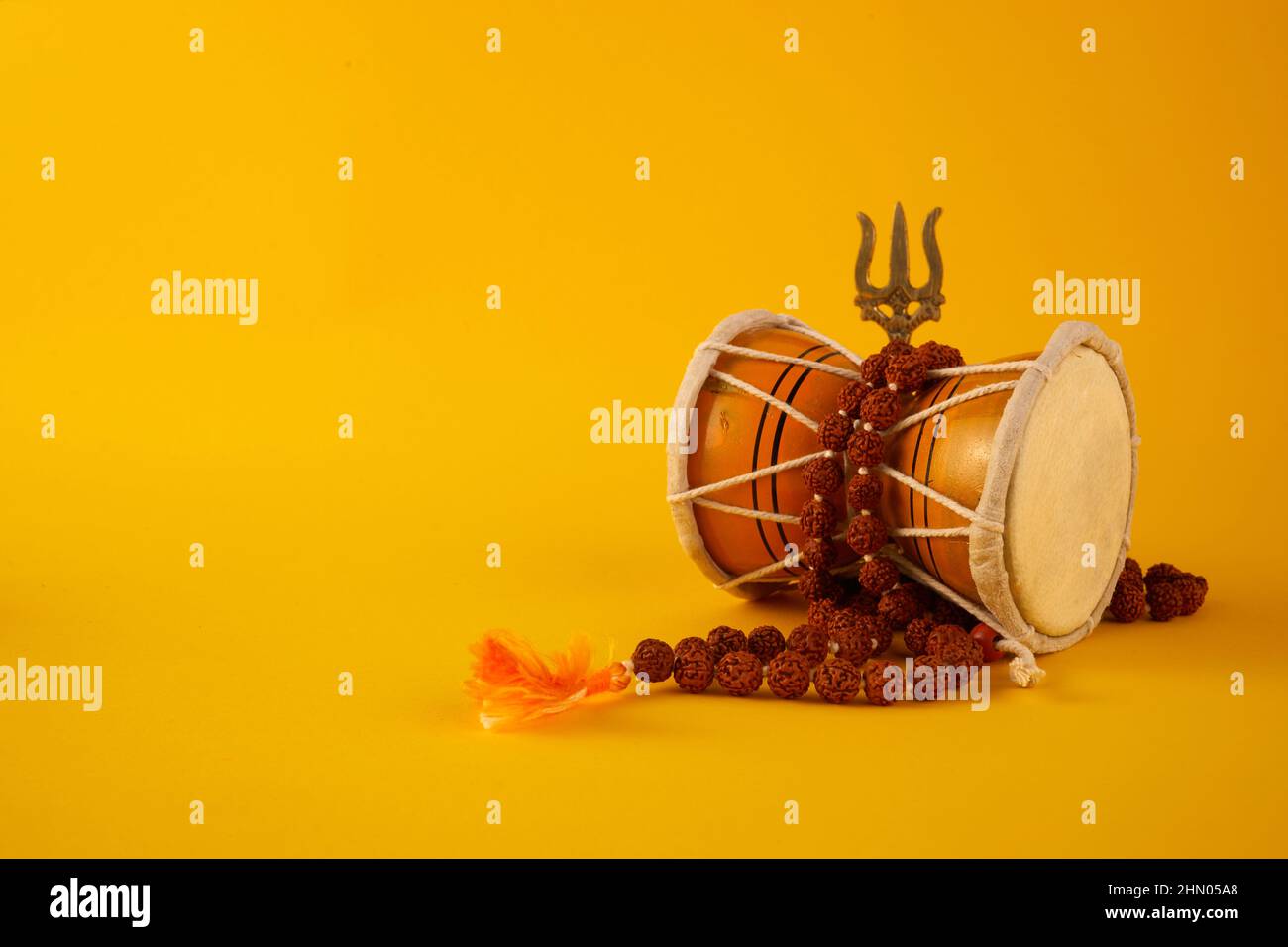 Shivaratri Hintergrund mit Shivas Dreizack und Pellet Drum Damroo Musikinstrument . Hindu-Fest Maha Shivratri Stockfoto