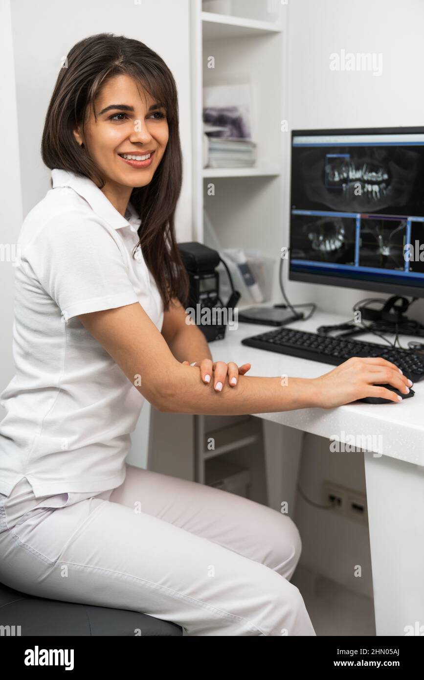 Zahnärztin, die an einem Computer in einem Röntgenraum arbeitet Stockfoto