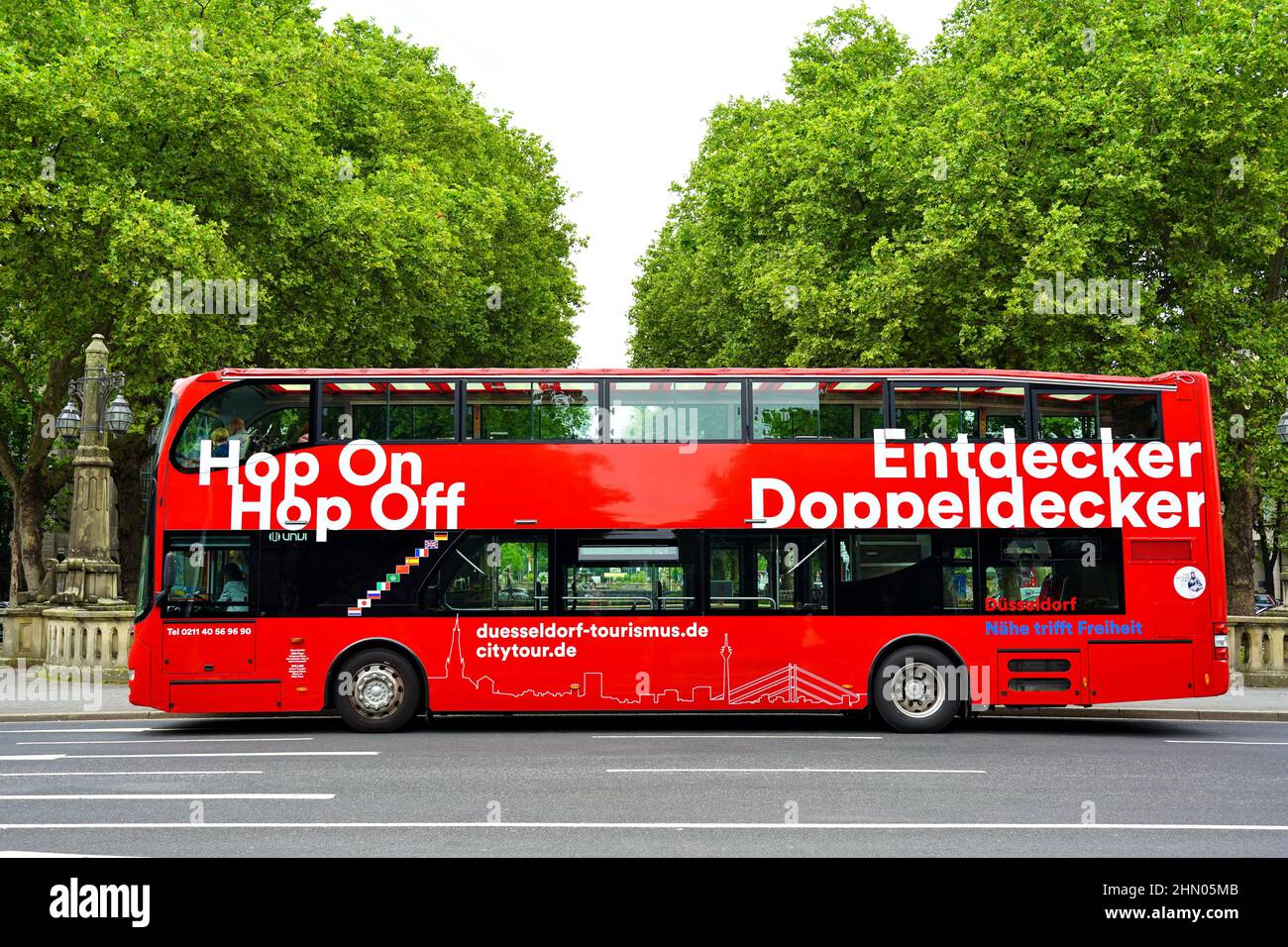 Rote Doppeldecker-Stadtrundfahrt 'Hop on / Hop off'-Bus wartet an einer Haltestelle in der Königsallee in Düsseldorf/Deutschland. Stockfoto