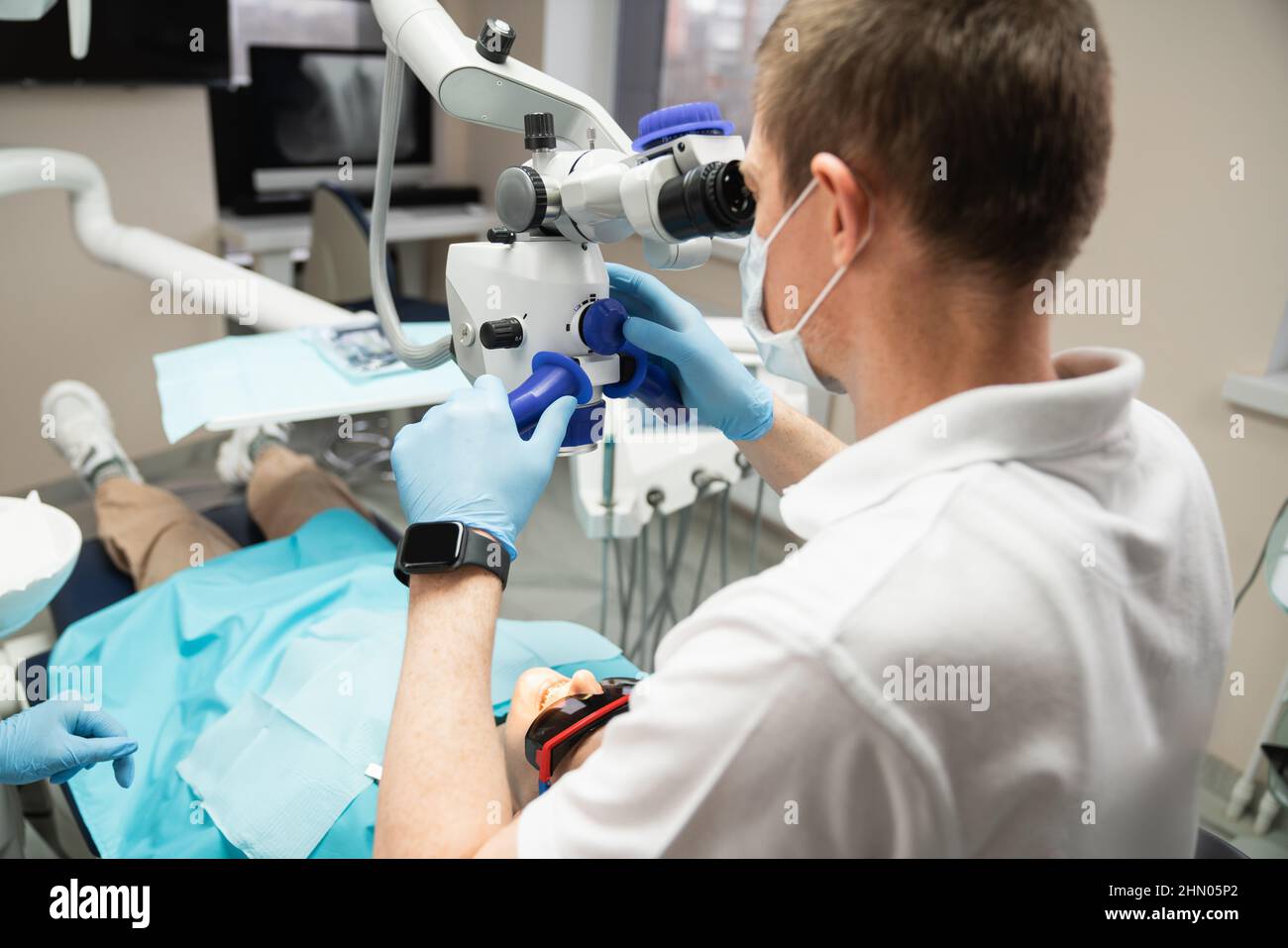 Zahnarzt macht eine Operation mit einem Zahnmikroskop Stockfoto