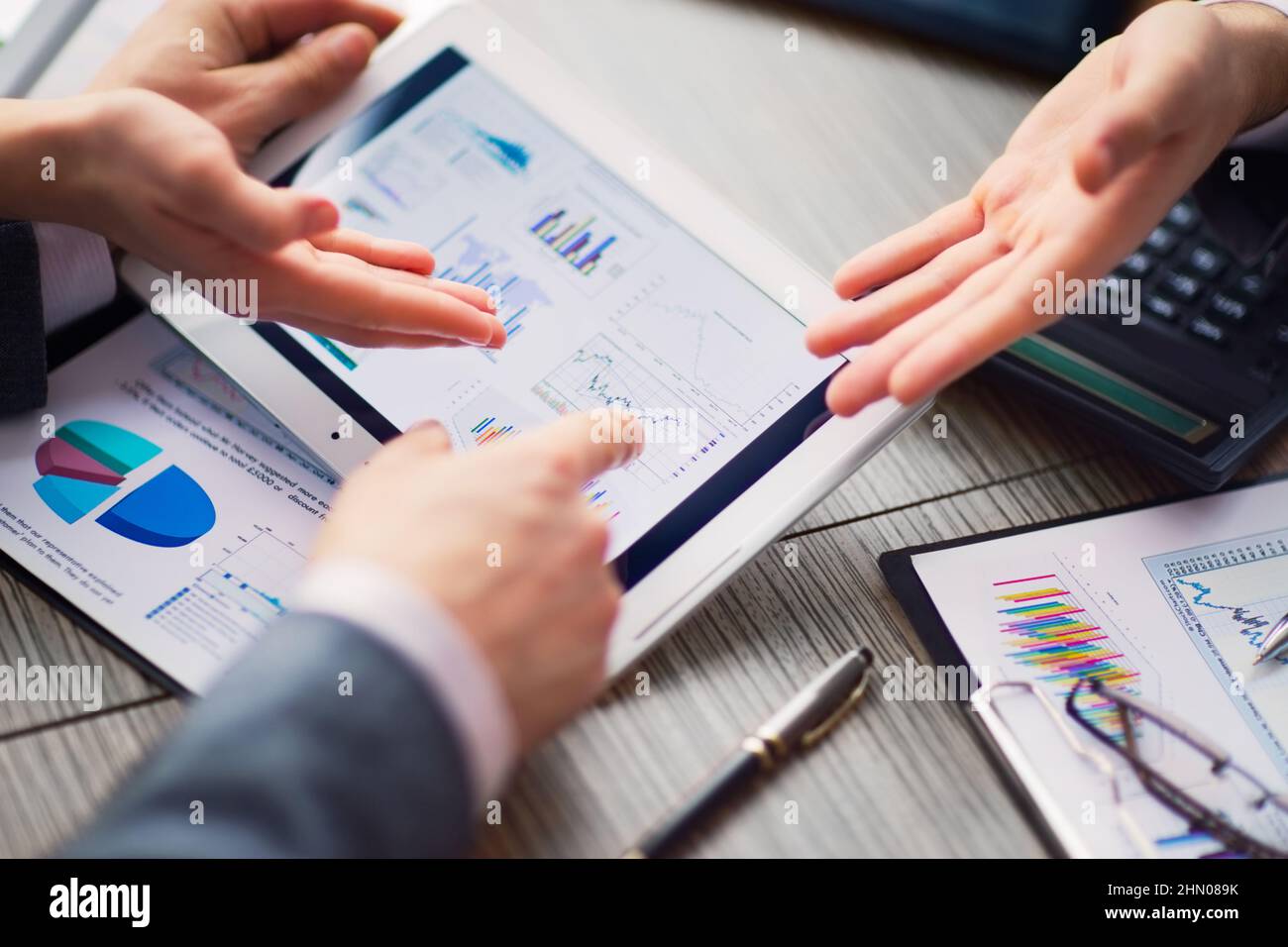 Geschäftsmann auf online Finanzielle Bewertung auf einem Tablett. Team die Arbeit im Büro Stockfoto