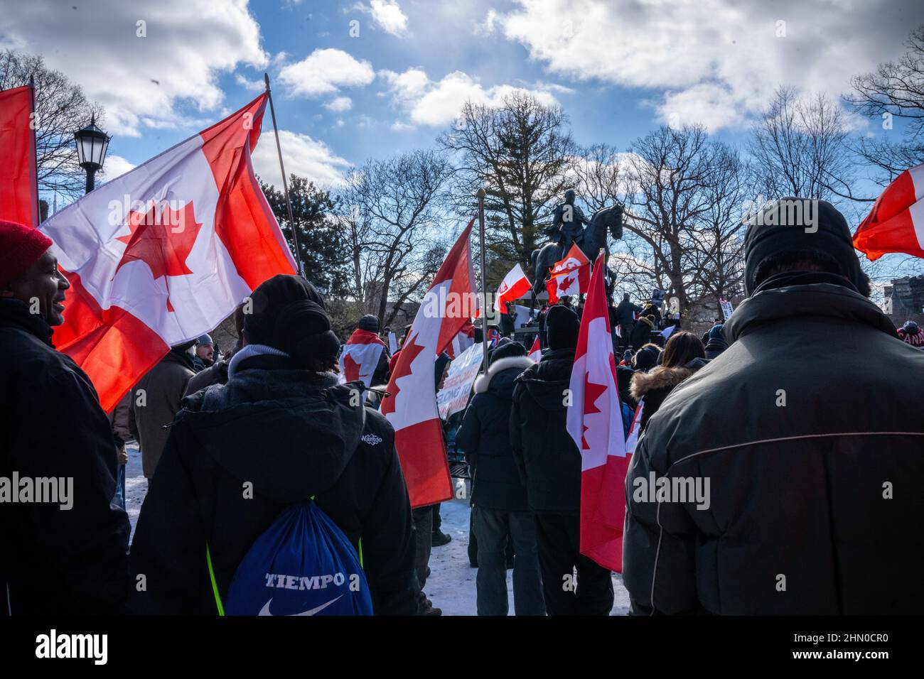 Toronto, Kanada. 12th. Februar 2022. Während einer Kundgebung sahen die Demonstranten, wie sie kanadische Flaggen um ein Denkmal schwenkten.Trucker Konvoi am zweiten Wochenende in Folge versammelten sich Demonstranten im Queen's Park, Toronto, um sich solidarisch mit Anti-Mandats-Demonstrationen zu zeigen. Er kommt, nachdem die Provinz den Ausnahmezustand in Bezug auf die anhaltenden Blockaden erklärt hat, und die Polizei von Toronto Straßensperrungen in der ganzen Stadt eingerichtet hat. (Foto von Katherine Cheng/SOPA Images/Sipa USA) Quelle: SIPA USA/Alamy Live News Stockfoto