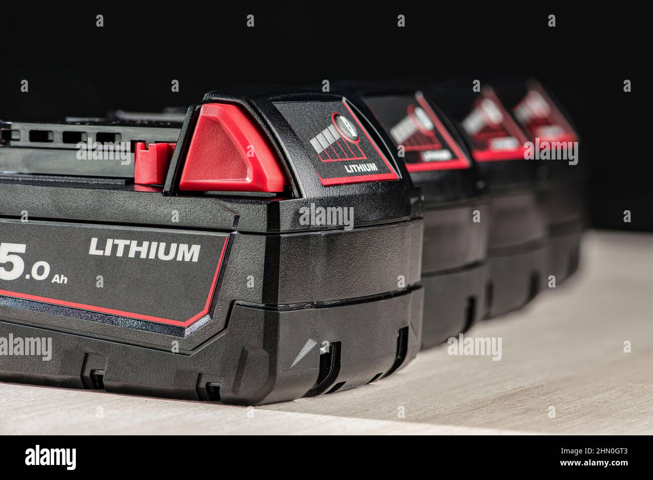 Akku für Akku-Bohrmaschine. Schrauberbatterie. Vier Akkus mit Ladeanzeige auf schwarzem Hintergrund Stockfoto