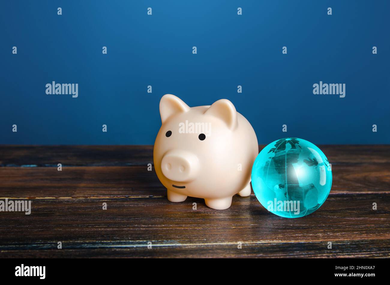Sparschwein und blauer Erdball. Weltfinanzsystem. Zahlungsdienste, internationale Geldtransfers. Finanzflüsse. Schutz der Einsparungen vor Stockfoto
