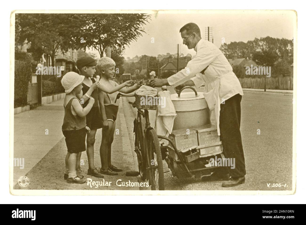 Originalpostkarte aus dem Archiv, bezaubernd aus den frühen 1920er Jahren, auf der 3 junge Jungen Eiszapfen (Kornett-Kornett) kaufen, von einem Eisverkäufer, der an einem heißen Sommertag Eis von einem Fahrrad verkauft, in einer englischen Vorstadtstraße, auf der Rückseite Kisten mit Crawfords Waffeln, um 1920, Großbritannien Stockfoto