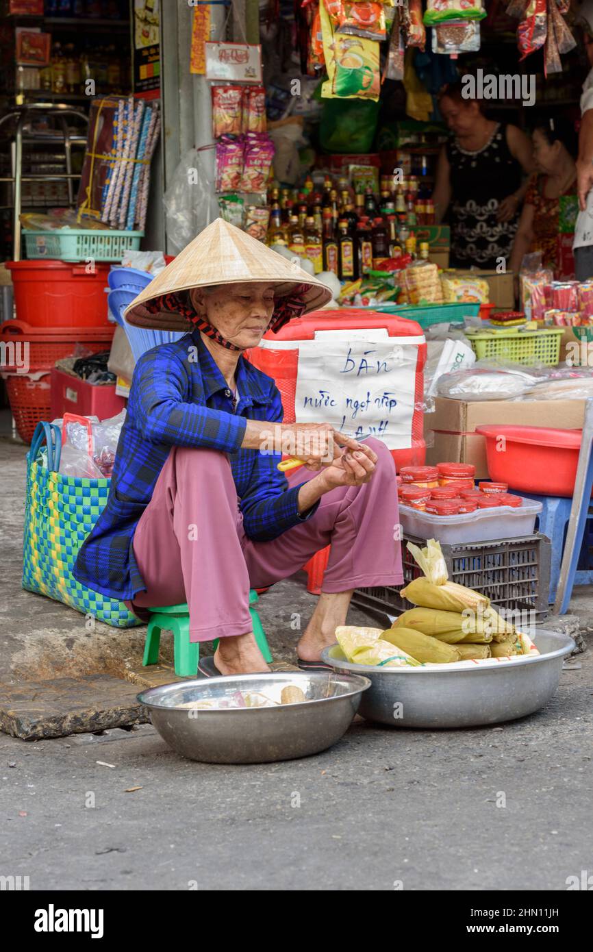 Eine reife Vietnamesin verkauft ihre Produkte auf dem geschäftigen Lebensmittelmarkt am Morgen in Cai Rang, in der Nähe von Can Tho, Mekong Delta, Südvietnam Stockfoto