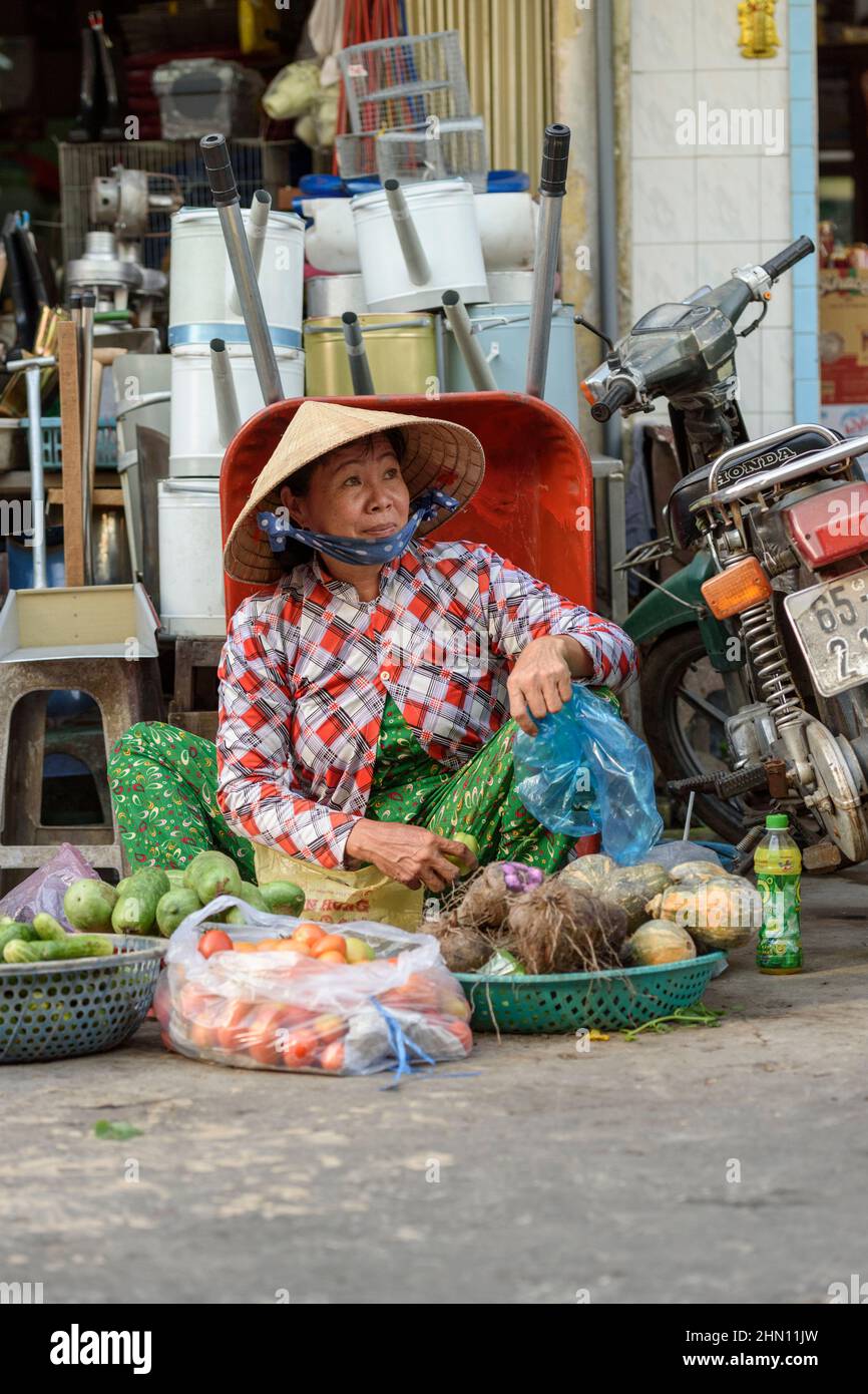 Eine reife Vietnamesin verkauft ihre Produkte auf dem geschäftigen Lebensmittelmarkt am Morgen in Cai Rang, in der Nähe von Can Tho, Mekong Delta, Südvietnam Stockfoto