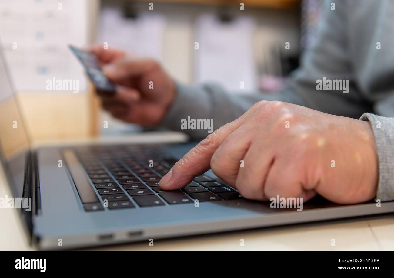 Eine Person, die eine Zahlungskarte verwendet, um online zu bezahlen. Stockfoto