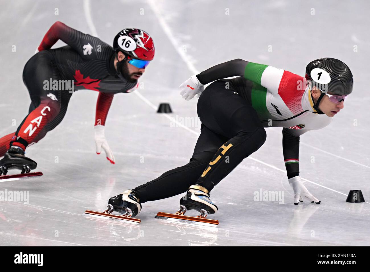 Peking, China. 13th. Februar 2022. Shaoang Liu aus Ungarn, #1, führt Steven Dubois aus Kanada, #16, während des Viertelfinals der Männer im Short Track Speed Skating 500m im Capital Indoor Stadium bei den Olympischen Winterspielen 2022 in Peking am Sonntag, den 13. Februar 2022, in eine Runde. Foto von Richard Ellis/UPI Credit: UPI/Alamy Live News Stockfoto