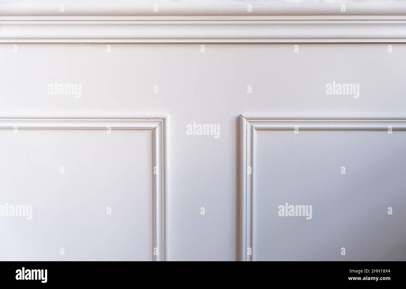 Klassische Holzverzierung mit Holzverzierung. Weißer Hintergrund der Wandtäfelung aus Holz im Retro-Stil, Nahaufnahme. Raumarchitektur im Innenbereich Stockfoto