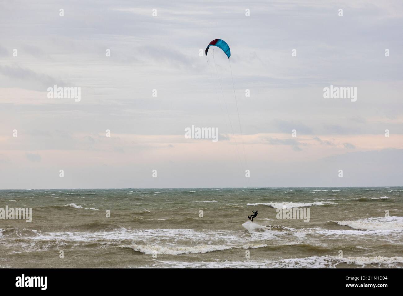 East Preston, Großbritannien, 13th. Februar 2022. Windsurfer, die bei starken Winden am East Preston Beach in West Sussex zum Wasser fahren. Quelle: Steven Paston/Alamy Live News Stockfoto