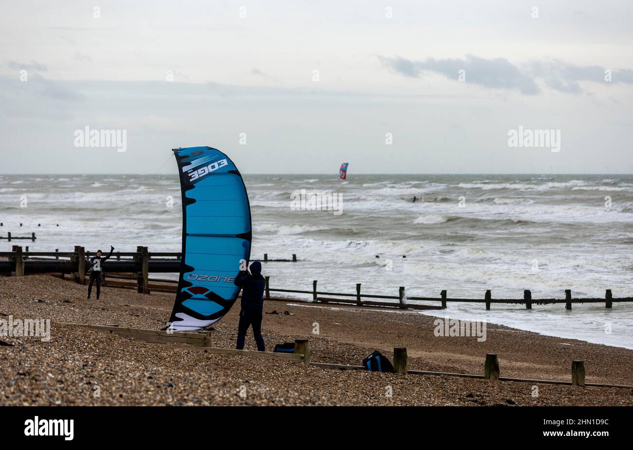 East Preston, Großbritannien, 13th. Februar 2022. Windsurfer, die sich aufmachen, bevor sie bei einigen starken Winden am East Preston Beach in West Sussex ins Wasser gehen. Quelle: Steven Paston/Alamy Live News Stockfoto