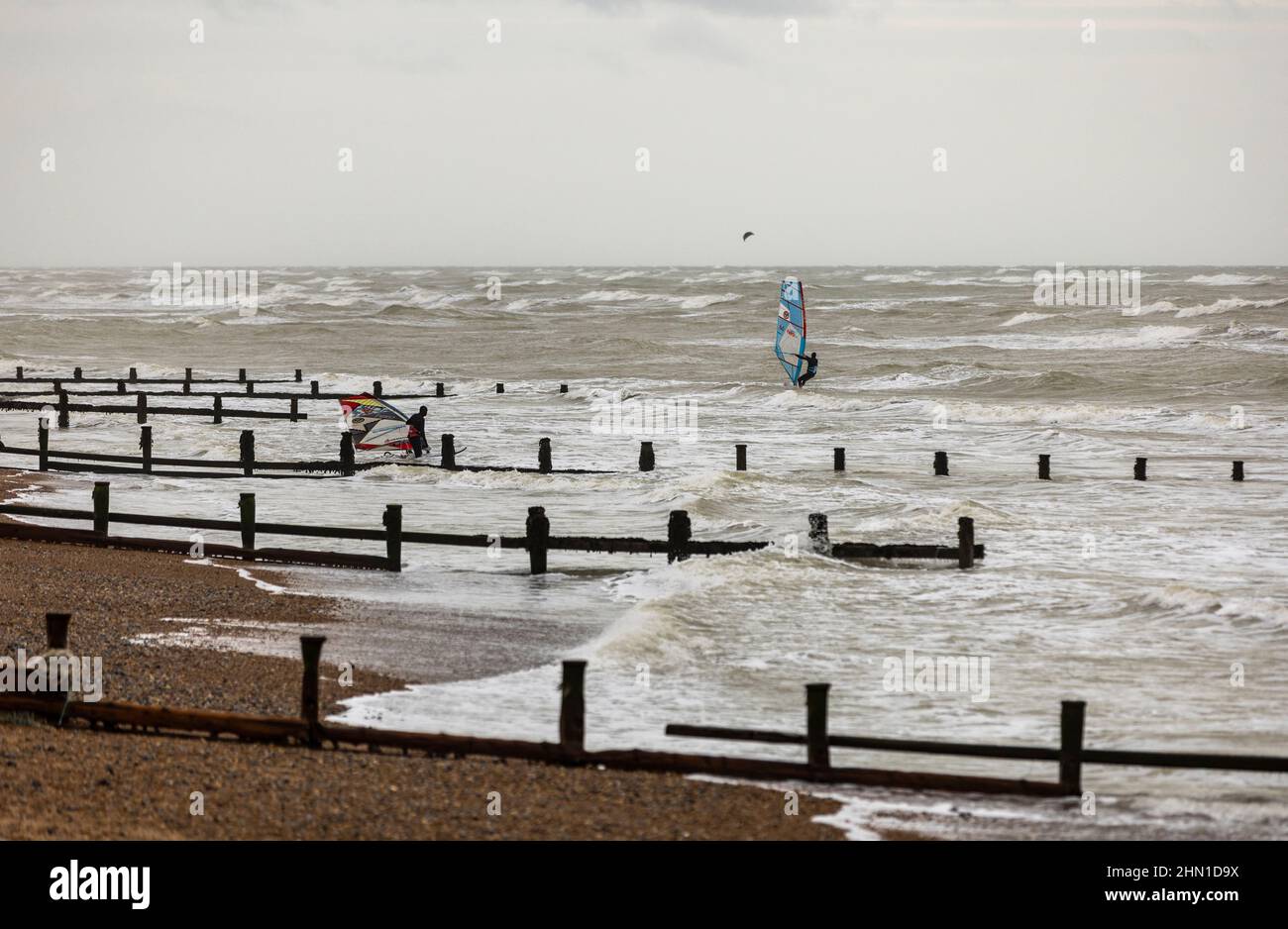 East Preston, Großbritannien, 13th. Februar 2022. Kitesurfer auf dem Wasser bei einigen starken Winden am East Preston Beach in West Sussex. Quelle: Steven Paston/Alamy Live News Stockfoto