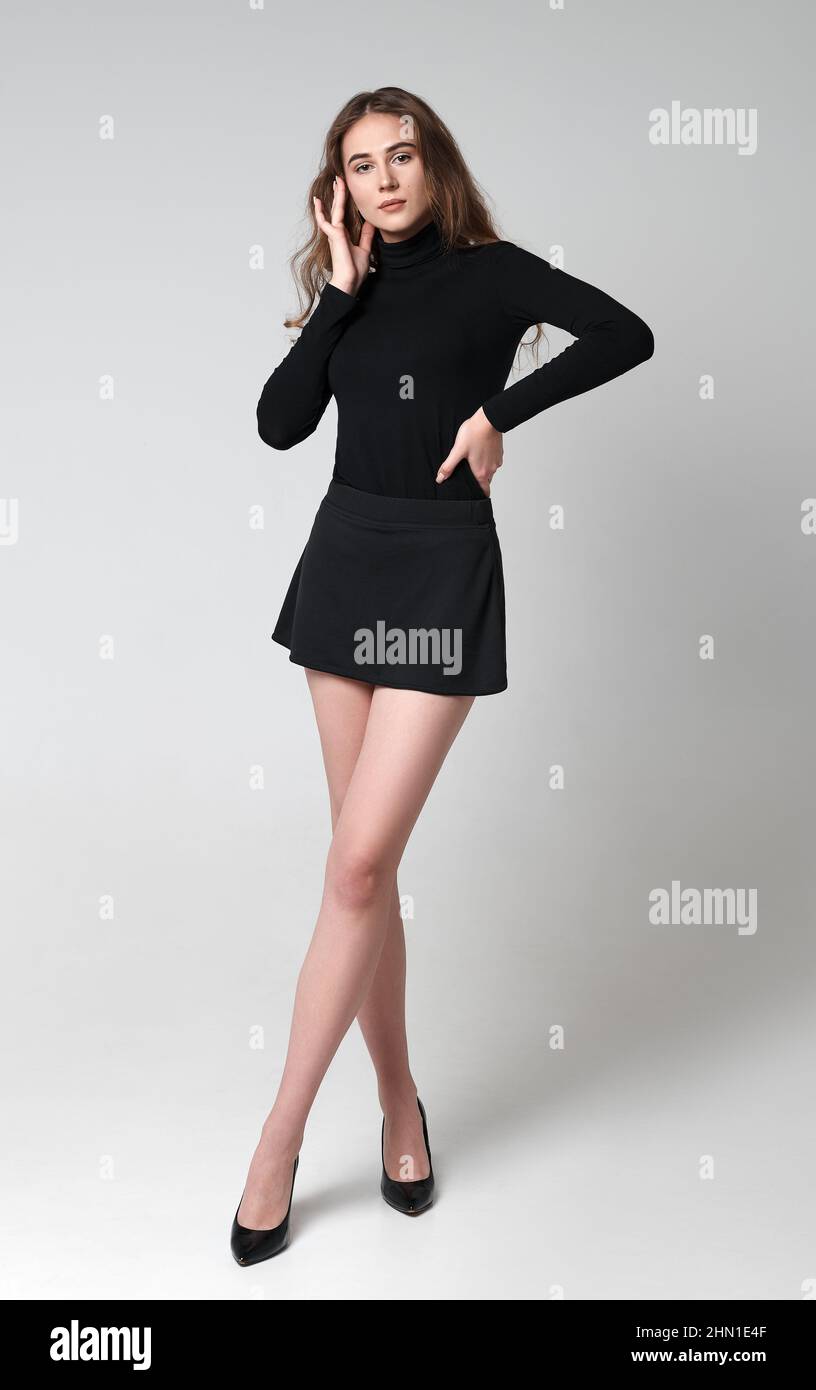 Studio Fashion SHOT: Porträt eines schönen jungen Mädchens in schwarzem Rock, Bluse und Schuhen in voller Länge. Modelltest Stockfoto