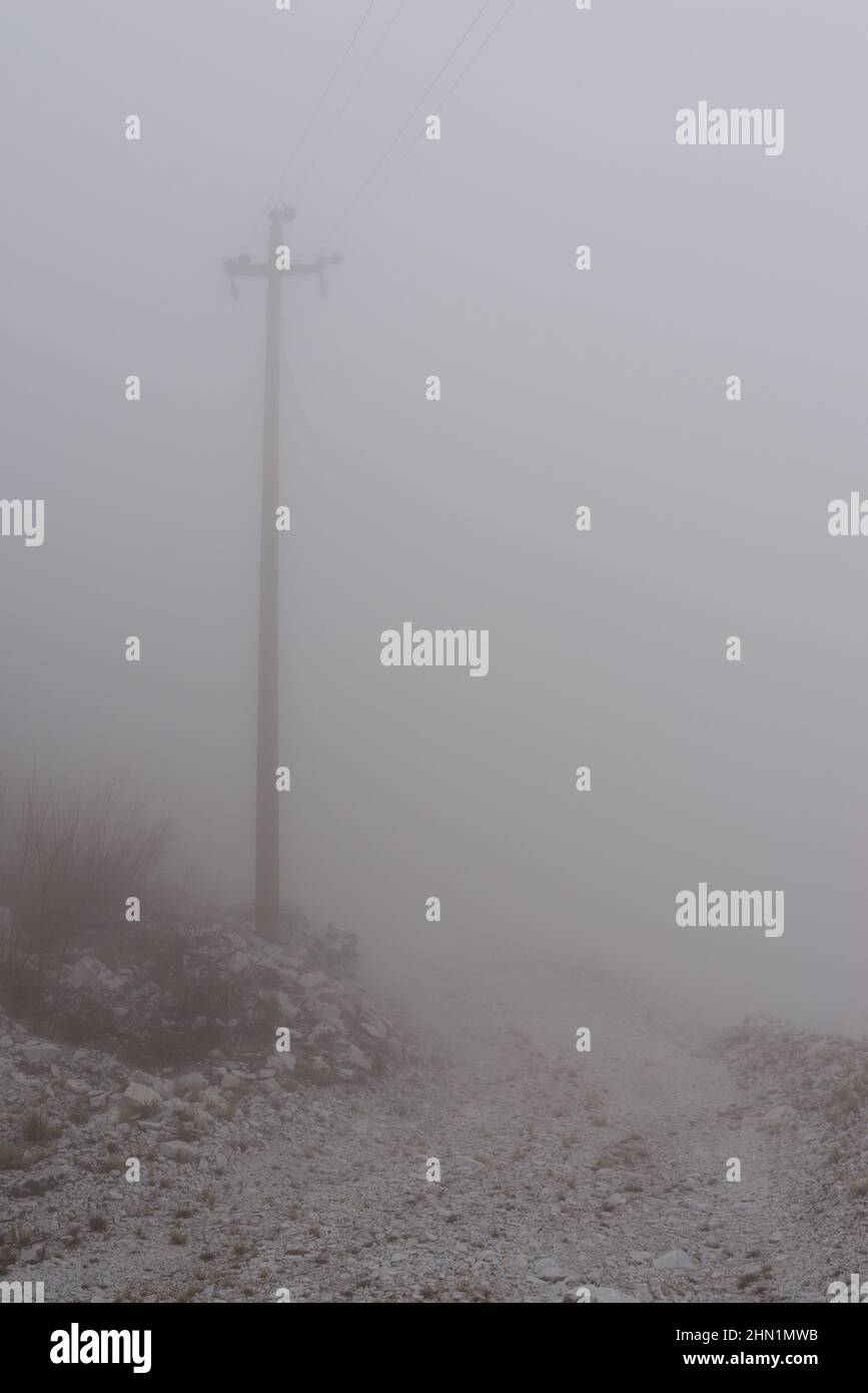 Strommast im Nebel in der Nähe des Marmorbruchs. Stockfoto