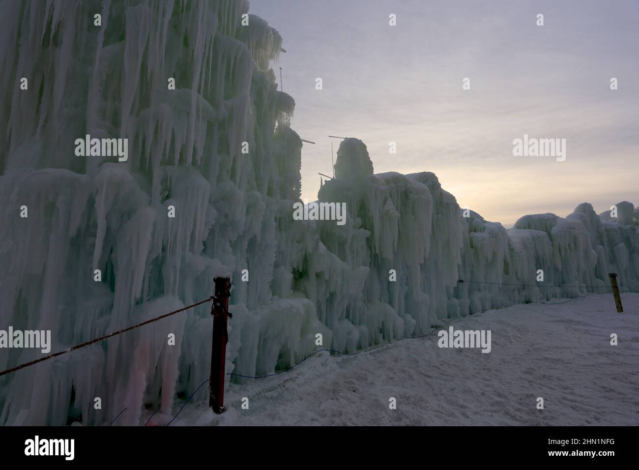 Eine Wand aus gefrorenen Eisblöcken und Eiszapfen, die am Genfer See, Wisconsin, USA, gegen den Himmel ragen Stockfoto