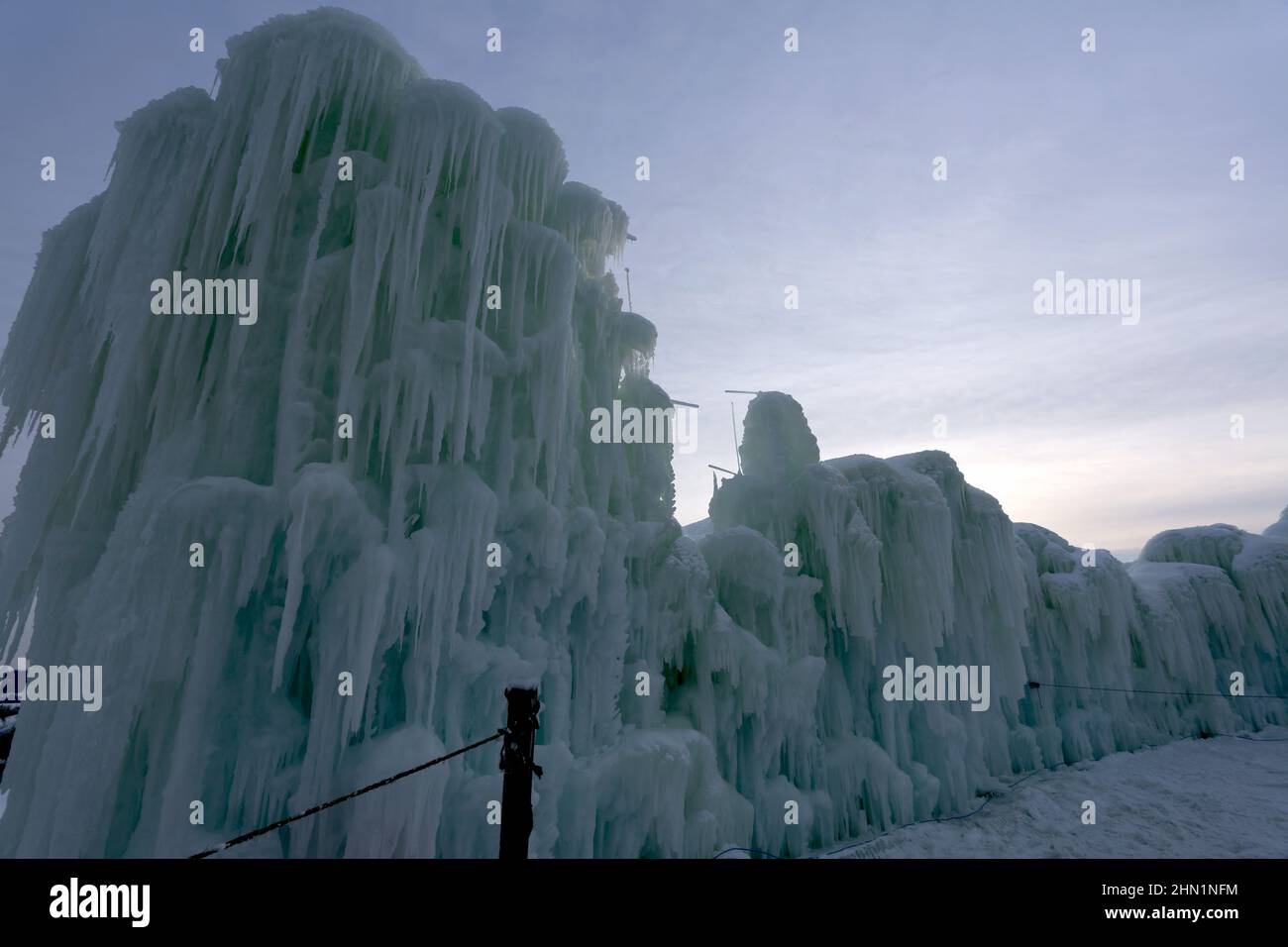 Eine Wand aus gefrorenen Eisblöcken und Eiszapfen, die am Genfer See, Wisconsin, USA, gegen den Himmel ragen Stockfoto