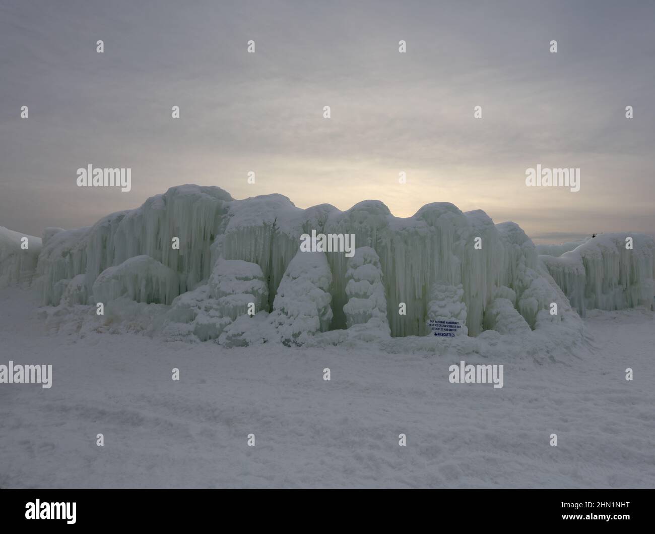 Eine Wand aus gefrorenem Wasser und Eiszapfen stand im Kontrast zum Sonnenuntergang an den Eisschlössern im Genfersee, Wisconsin, USA Stockfoto