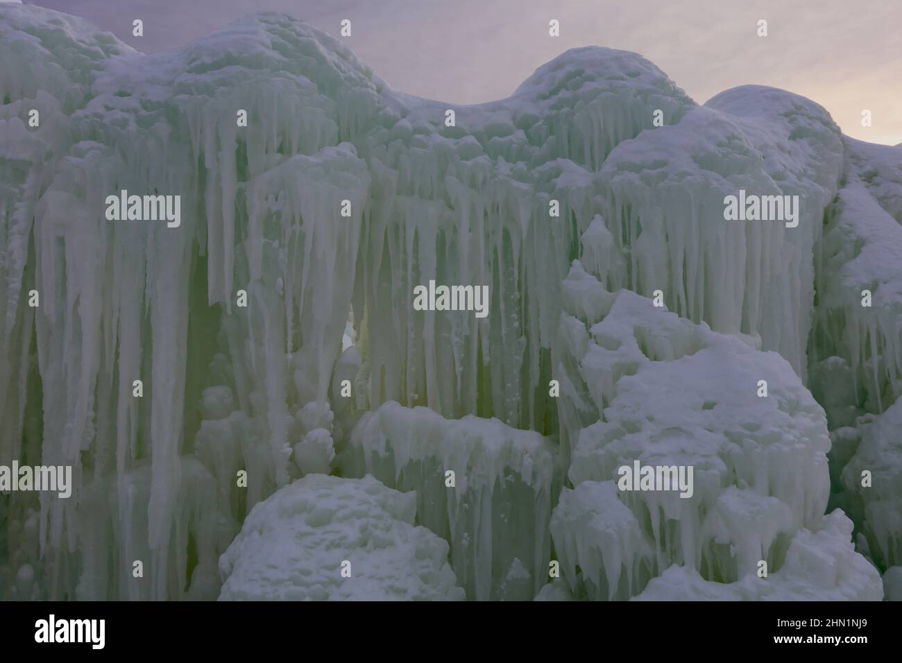 Eine Wand aus gefrorenem Wasser und Eiszapfen stand im Kontrast zum Sonnenuntergang an den Eisschlössern im Genfersee, Wisconsin, USA Stockfoto