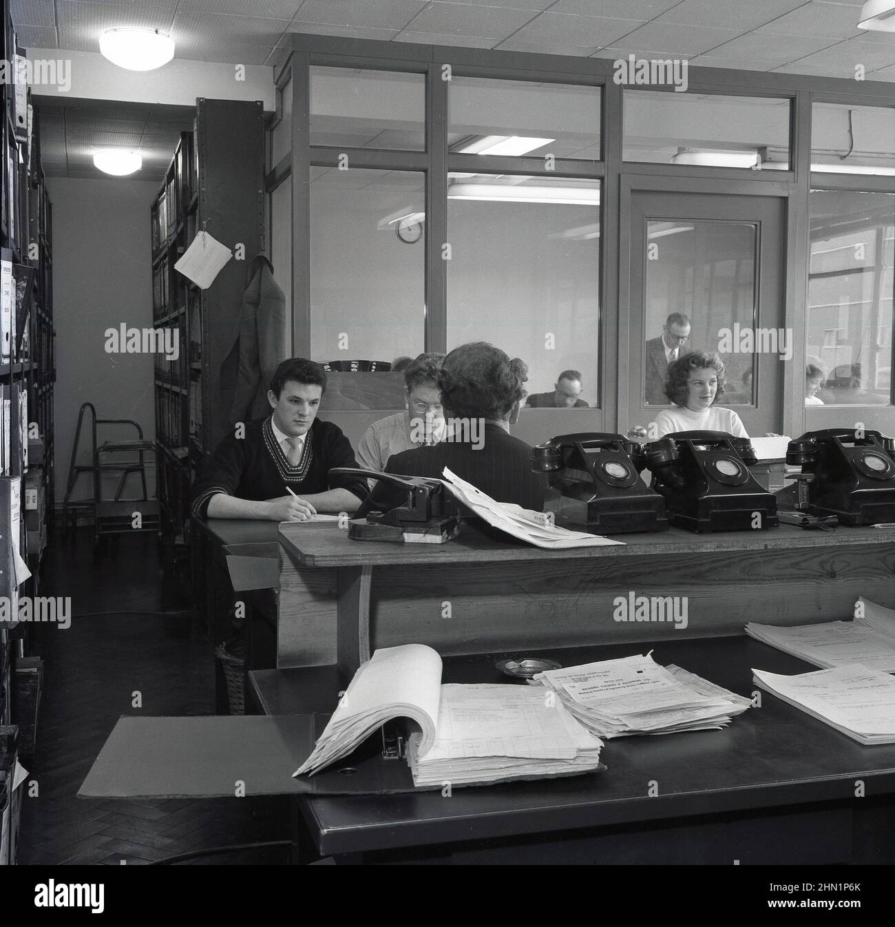 1950s, historisch, Büroangestellte an Schreibtischen in der Verwaltungsabteilung der Steel Company of Wales, Abbey Works, Port Talbot, Wales, Großbritannien, Zeigen von Papierkram und Telefonen der damaligen Zeit. Stockfoto