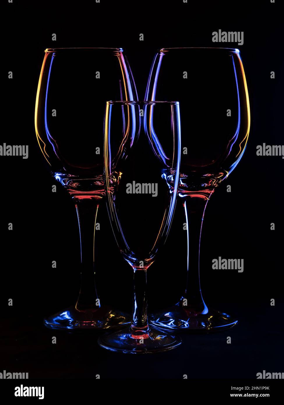 Drei Weingläser, hintergrundbeleuchtetes Stillleben mit Copyspace. Stockfoto