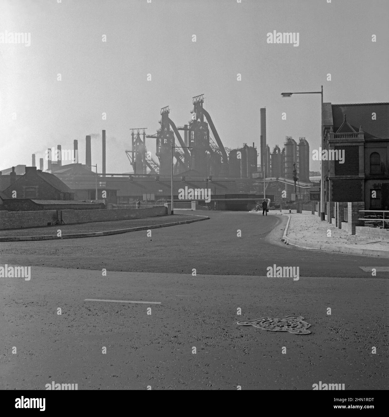 Ein Blick auf Central Road, Port Talbot, West Glamorgan, Wales, UK c.. 1960 von der Kreuzung mit der Commercial Road. Die Central Road war eine der Hauptzufahrtsstraßen zu den Stahlwerken (im Hintergrund zu sehen), die sich in den Nachkriegsjahren stark erweitert hatten (siehe Alamy-Bild 2HN1RG0 für einen Blick auf die Bauarbeiten an der Straßenbrücke über die Ffrwd Wyllt). Die Dyffryn-Kapelle befindet sich auf der rechten Seite. Schließlich war die Hauptroute zu den Werken über die Cefn Gwrgan Road. Beide Zufahrtsstraßen wurden jedoch durch das Gebäude der Hafenstraße im Jahr 2013 abgeschnitten – ein altes Foto aus dem Jahr 1950s/60s. Stockfoto