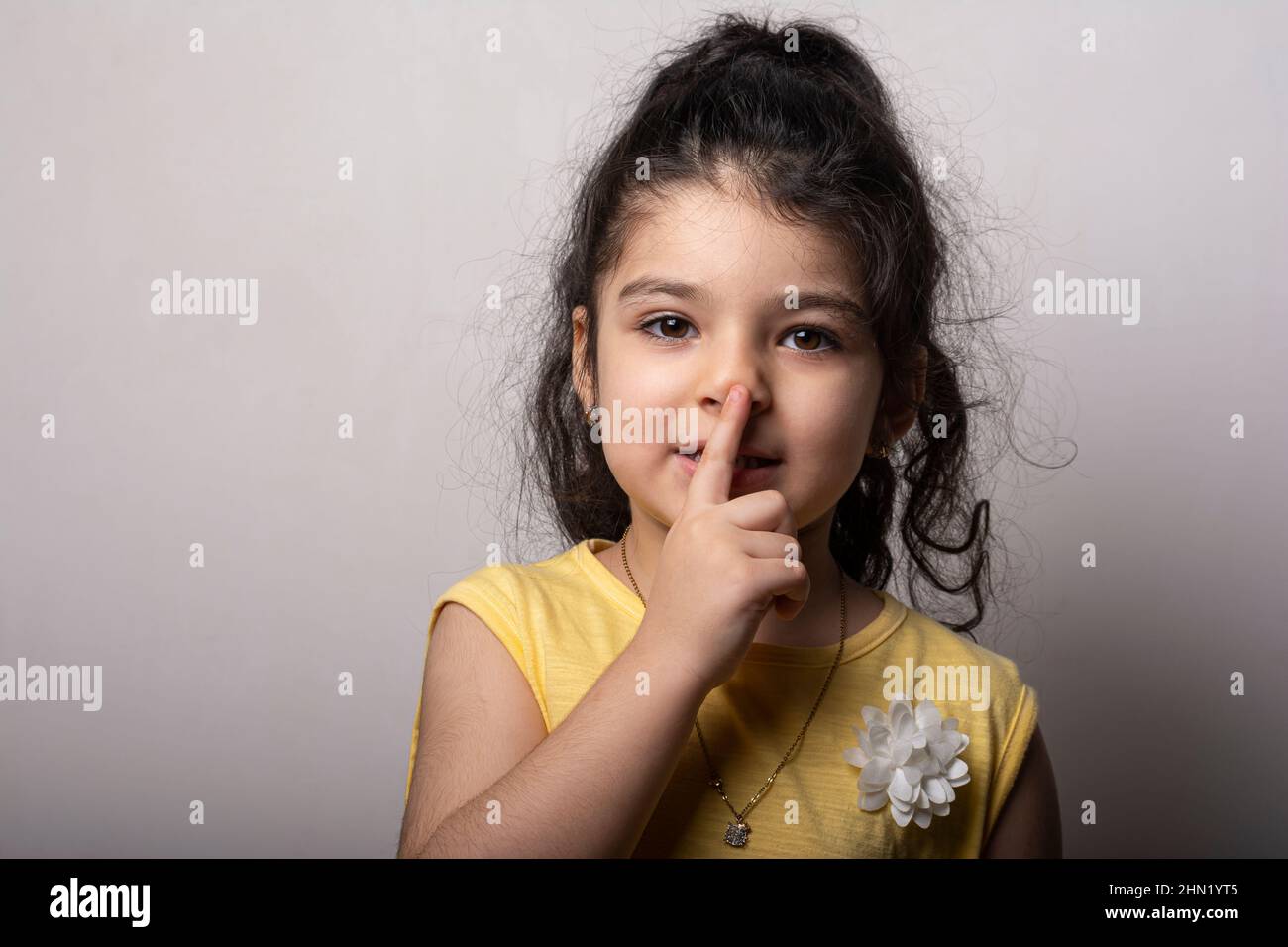 Porträt eines kleinen Mädchen geheim halten legte Finger in die Nähe der Lippen Zeichen zu schweigen Stockfoto