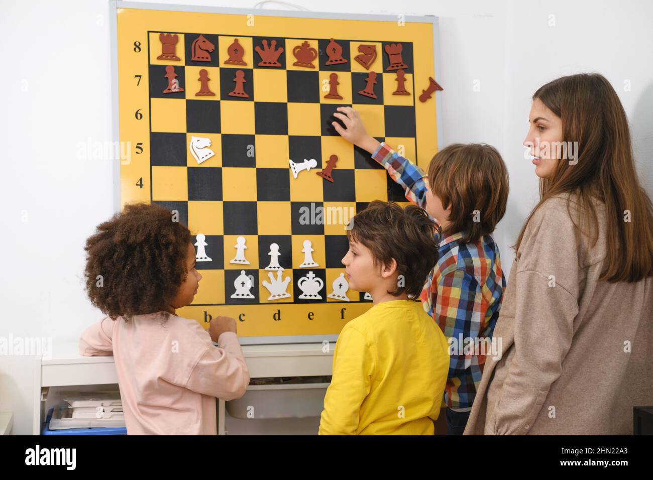 Child Thinking Hard on Chess Kombinationen an der Wand auf Turnier für Kinder Geistiges Spiel, Hobby für Kinder Stockfoto