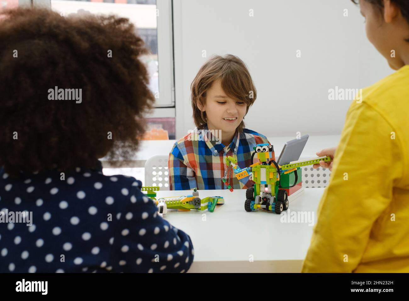 Junge In Der Schule Computer Codierung Klasse Gebäude Und Lernen, Roboterfahrzeug Zu Programmieren. Multiethnische Kinder, die Wissenschaft, Technologie und Codierung Aufgaben Stockfoto